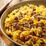 Close-up of a delicious dinner with ground beef and noodles, garnished with herbs.