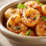 Close-up of high-protein honey garlic shrimp with a glossy sauce and garnished with herbs.