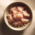 Close-up of a creamy chicken dish in a slow cooker with herbs