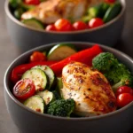 Close-up of meal prep chicken bowls with vibrant ingredients and a clean background