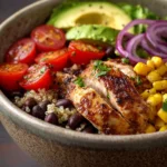 Close-up of a Mexican chicken quinoa bowl with vibrant ingredients and creamy sauce.