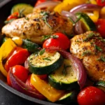 Close-up of a one pan chicken and veggies dish with bright colors and clean presentation