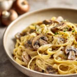 Close-up of one pot pasta with mushrooms in a creamy sauce, garnished with herbs.
