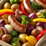 Close-up of a sheet pan dinner with sausage and roasted vegetables on a baking tray