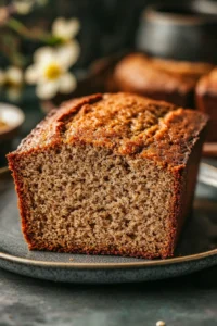 Close-up of banana bread made with oat flour, showing a slice with a golden crust and soft interior.